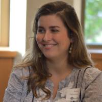 Alumna smiling while listening to a conversation